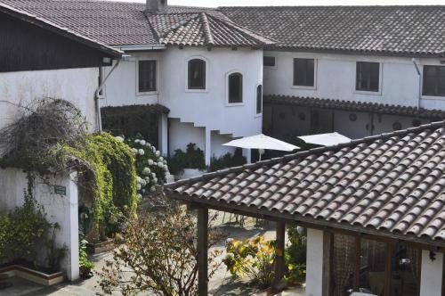 a group of white houses with umbrellas in a yard at Hosteria Iloca in Iloca