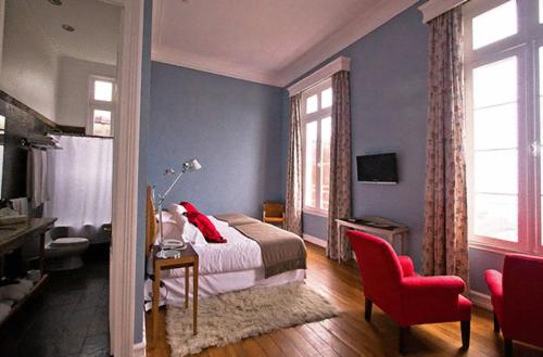 a bedroom with a bed and a red chair at Zerohotel in Valparaíso