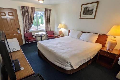 a hotel room with a bed and a table and chairs at Fairground Inn in Monroe