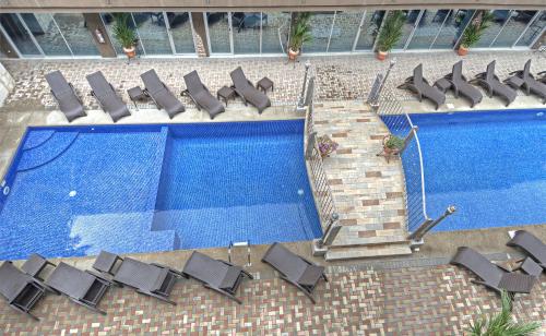 an overhead view of two swimming pools with lounge chairs at Beachfront Hotel Tramonto in Jacó