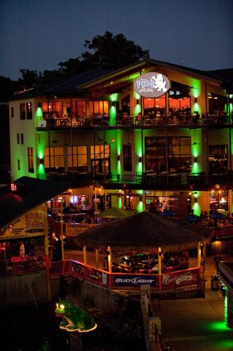 a building with a restaurant with green lights at night at Camden on the Lake Resort in Lake Ozark
