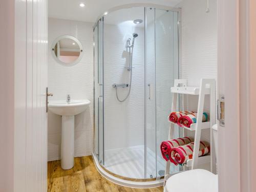 a bathroom with a shower and a sink at Cobblers Cottage in Glendale