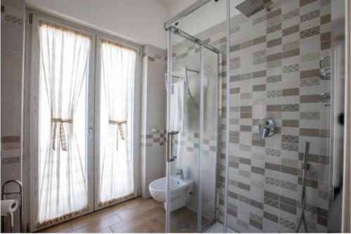 baño con ducha y aseo y ventana en La Razza Home&Restaurant en Gragnano