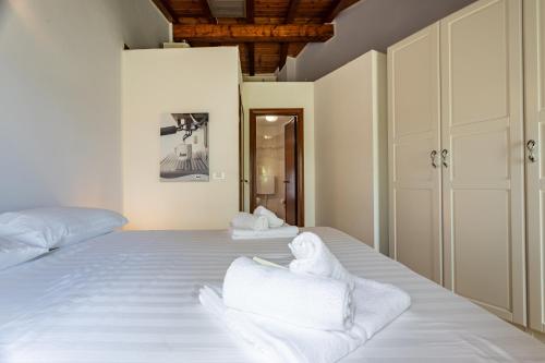 2 bedden in een kamer met witte lakens en handdoeken bij Appartamento Al Vigneto in Montorio Veronese