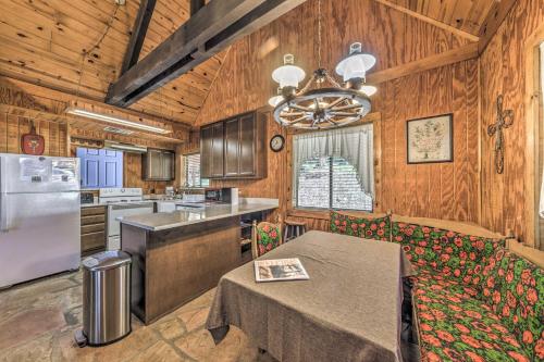 a kitchen with wooden walls and a table and a refrigerator at Peaceful and Private Cloudcroft Cabin with Deck! in Cloudcroft