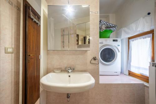 a bathroom with a sink and a washing machine at Appartamento Al Vigneto in Montorio Veronese