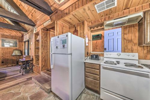a kitchen with white appliances and wooden walls at Peaceful and Private Cloudcroft Cabin with Deck! in Cloudcroft