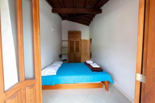 a small bedroom with a blue bed in a room at Apartamentos Primavera in Jardin