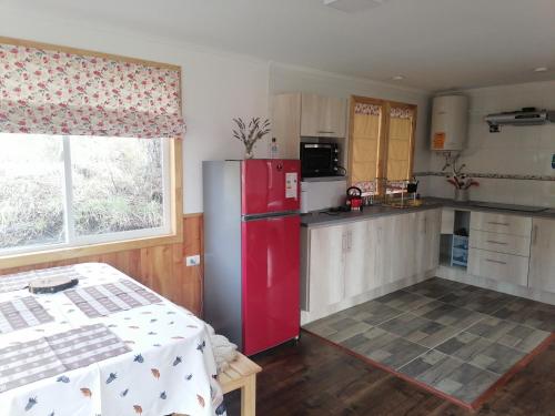 科伊艾科的住宿－Cabaña Turismo EL SUSURRO，一间厨房,在房间内配有红色冰箱