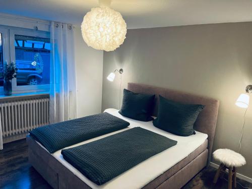 a bedroom with two beds with blue pillows and a chandelier at Ferienhaus Sauerland - Traum in Winterberg