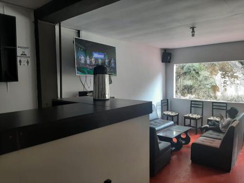 a living room with a black counter and a tv at Casa Machu Picchu Hostel in Machu Picchu