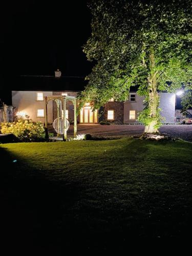 a house with a gazebo in the yard at night at The Granary, Luxuriously Restored Barn on a Farm in Thurles