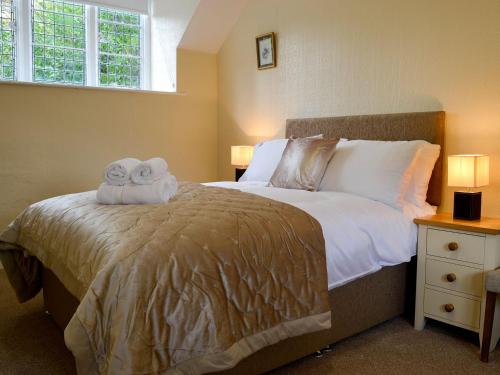 a bedroom with a bed with two towels on it at The East Wing At Grove Hall in Bodfari