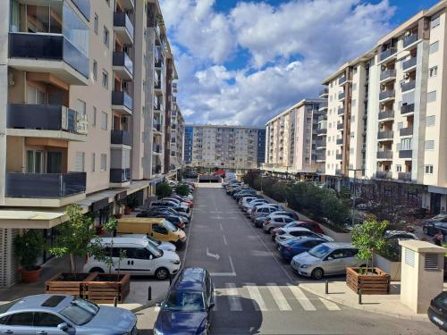 un parking plein de voitures garées dans une ville dans l'établissement Apartman City kvart, à Podgorica