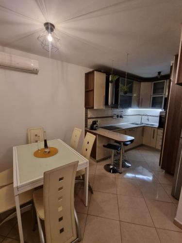 una cocina con mesa y sillas blancas, mesa, mesa y sillas en Apartman Đana, en Split