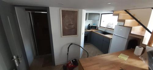 a kitchen with a refrigerator and a counter top at T3 calme et cosy, idéalement situé près du château et de la gare, dans un cadre paisible in Rambouillet