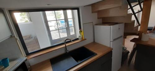 a small kitchen with a sink and a window at T3 calme et cosy, idéalement situé près du château et de la gare, dans un cadre paisible in Rambouillet