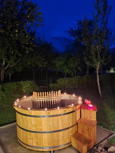 una bañera de hidromasaje de madera con luces en un patio por la noche en Casa Valle, en Brod na Kupi