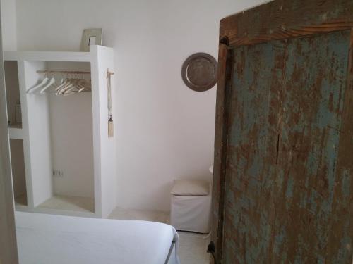 a room with a bed and a closet with a door at Corte Moline in Gallipoli