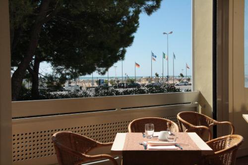 a table and chairs on a balcony with a large window at Hotel Ambassador in Bibione