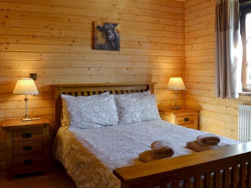 a bedroom with a bed with two nightstands and two lamps at Exmoor - Uk12539 in Witheridge