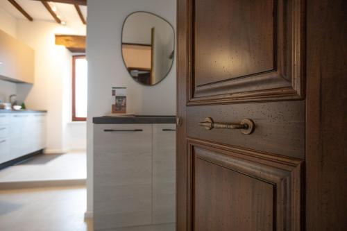 a bathroom with a wooden door and a mirror at Appartamento centro storico Gubbio in Gubbio