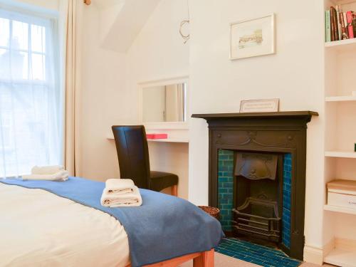 a bedroom with a bed and a fireplace at Lythdene in Grange Over Sands