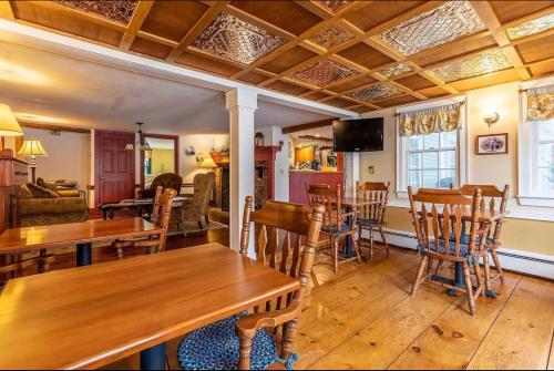 uma sala de estar com mesas e cadeiras de madeira em Chester Inn em Chester