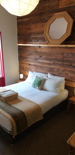 a bedroom with a large bed with a wooden wall at Treehouse Patagonia in Puerto Natales