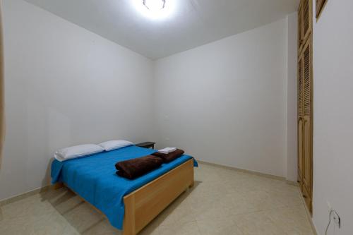 a bedroom with a bed with a blue comforter at Apartamentos Primavera in Jardin