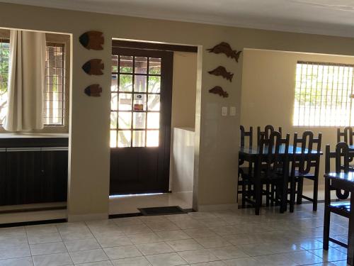 una sala da pranzo con porta, tavolo e sedie di Pousada Costa dos Corais a São José da Coroa Grande
