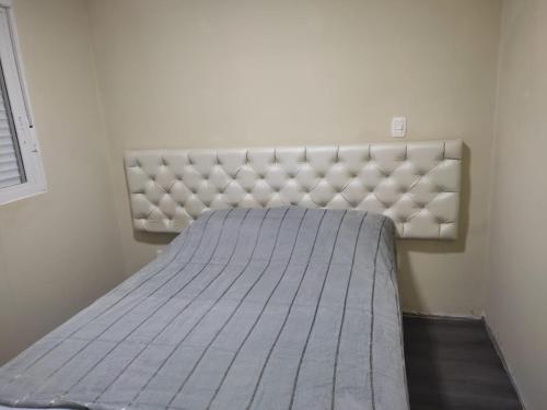 a bed in a room with a white mattress at Residencial Recanto Verde in Canela