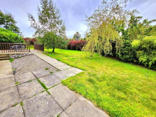 um quintal relvado com uma mesa de piquenique e árvores em Boutique Four Bed Holiday Home in Inverness em Inverness