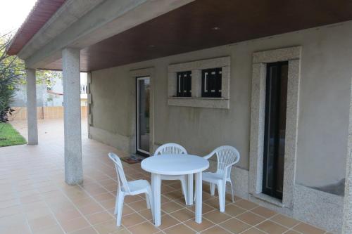 a white table and chairs on a patio at Sweet Home Braga Hostel & Guest House in Braga