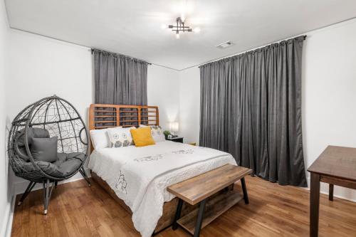 1 dormitorio con cama, silla y escritorio en Saffron Door Sanctuary, near downtown Atlanta! en Atlanta