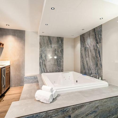 un ampio bagno con una grande vasca di Homestay Suites - Studios & Spas a Moreno Valley