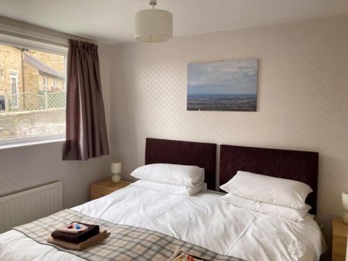 a bedroom with a bed with white sheets and a window at Vale View in Richmond
