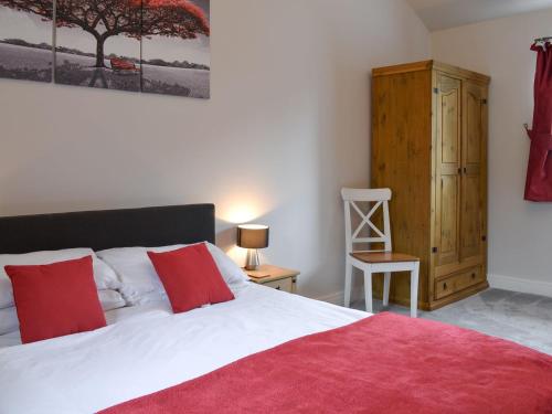 a bedroom with a large bed and a wooden cabinet at Mill Force Cottage in Bowes