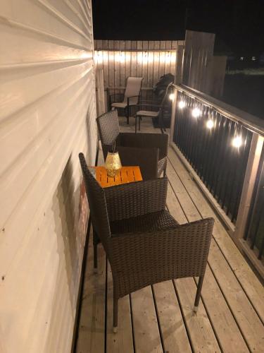 a table and chairs on a balcony at night at Alma’s Cape Shore Cottage! Your home away from home! in Bonavista