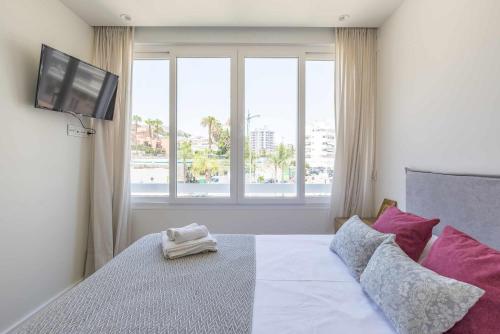 a bedroom with a bed with a flat screen tv at Eurosol sunny beach apartment in Torremolinos