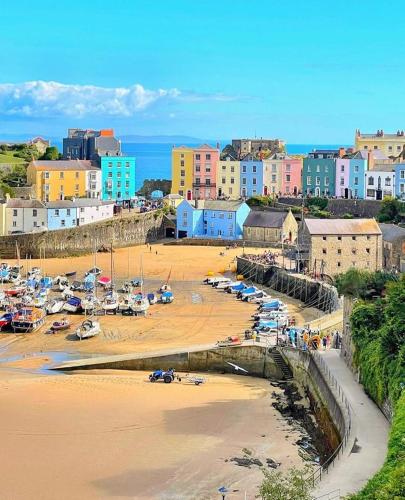 a beach with a bunch of boats in the sand at Gwandalan - 1 Bed Apartment, Within Tenby Town Walls in Tenby