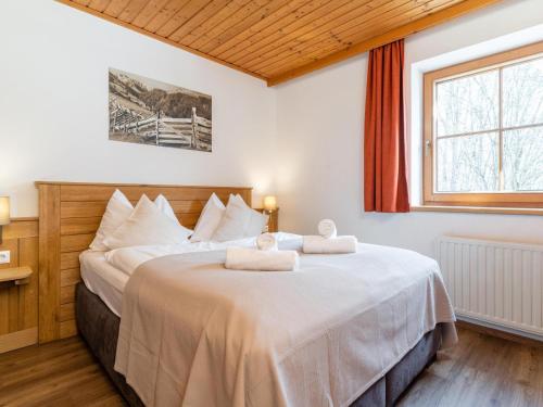 - une chambre avec un grand lit et 2 serviettes dans l'établissement Alpensteinbock Saalbach A, à Saalbach-Hinterglemm