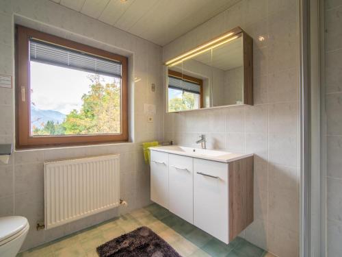 a bathroom with a sink and a mirror and a toilet at Chalet Rosa in Reith im Alpbachtal