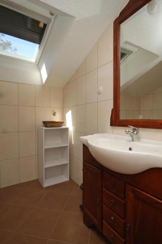 a bathroom with a sink and a mirror at Apartment Karkavac - Scedro 8801a in Jelsa