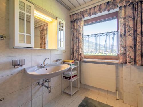 ein Bad mit einem Waschbecken und einem Fenster in der Unterkunft Ferienwohnung Horvath in Uderns