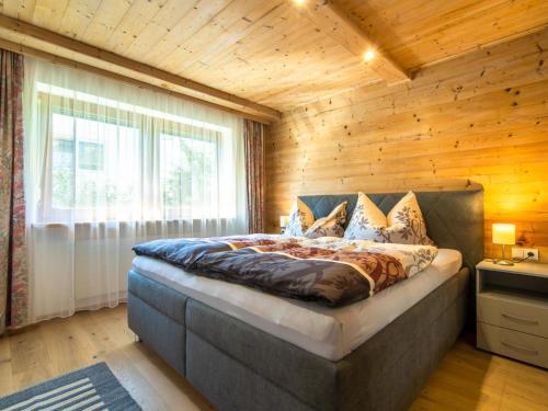 ein Schlafzimmer mit einem Bett mit einer Holzwand in der Unterkunft Ferienwohnung Horvath in Uderns