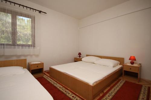 sypialnia z dwoma łóżkami i oknem w obiekcie Apartments by the sea Vrboska (Hvar) - 8748 w mieście Vrboska