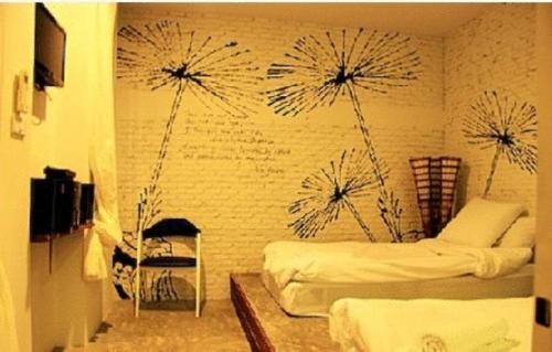 a bedroom with two beds with dandelions on the wall at White@Sea Resort in Ban Phe