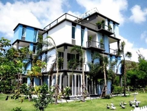a large building with birds in front of it at White@Sea Resort in Ban Phe