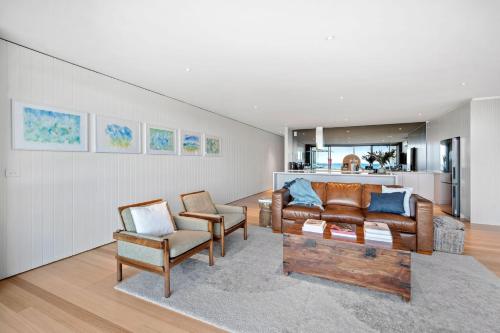a living room with a couch and chairs and a kitchen at Louttit Bay Apartment 1 in Lorne